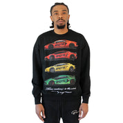 A man with braided hair models the CAUTION TO THE WIND CREWNECK SWEATSHIRT BLACK, an oversized heavyweight French terry piece with puff print red, yellow, and green sports cars stacked vertically over text on a white background.